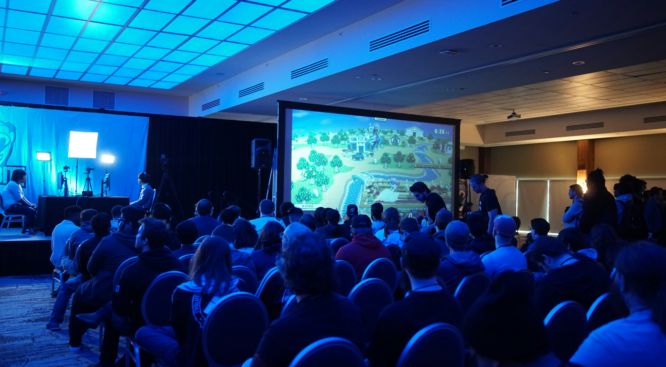 Conference audience watching a presentation under blue lighting