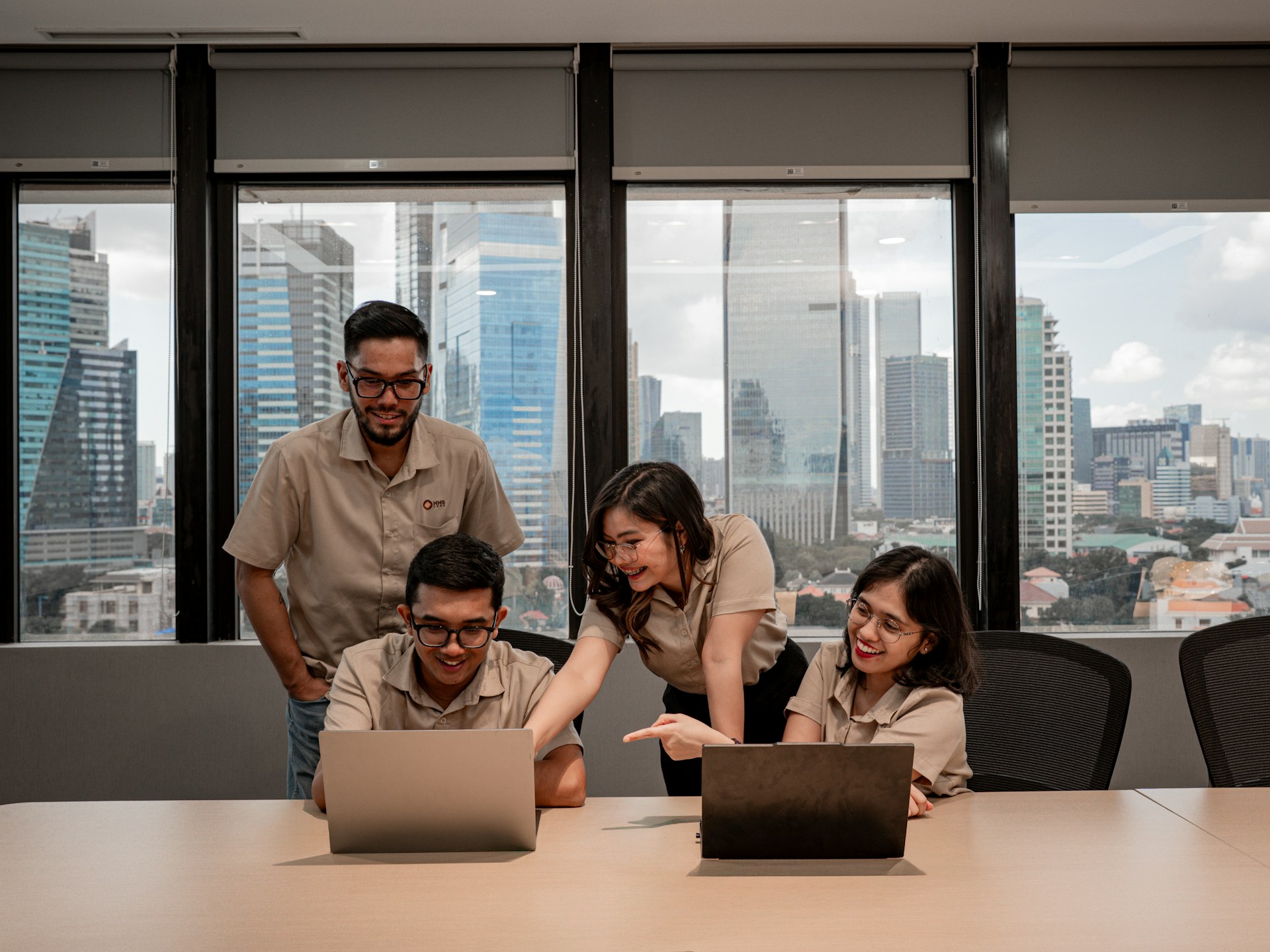 Coworkers collaborating around laptops in a modern office