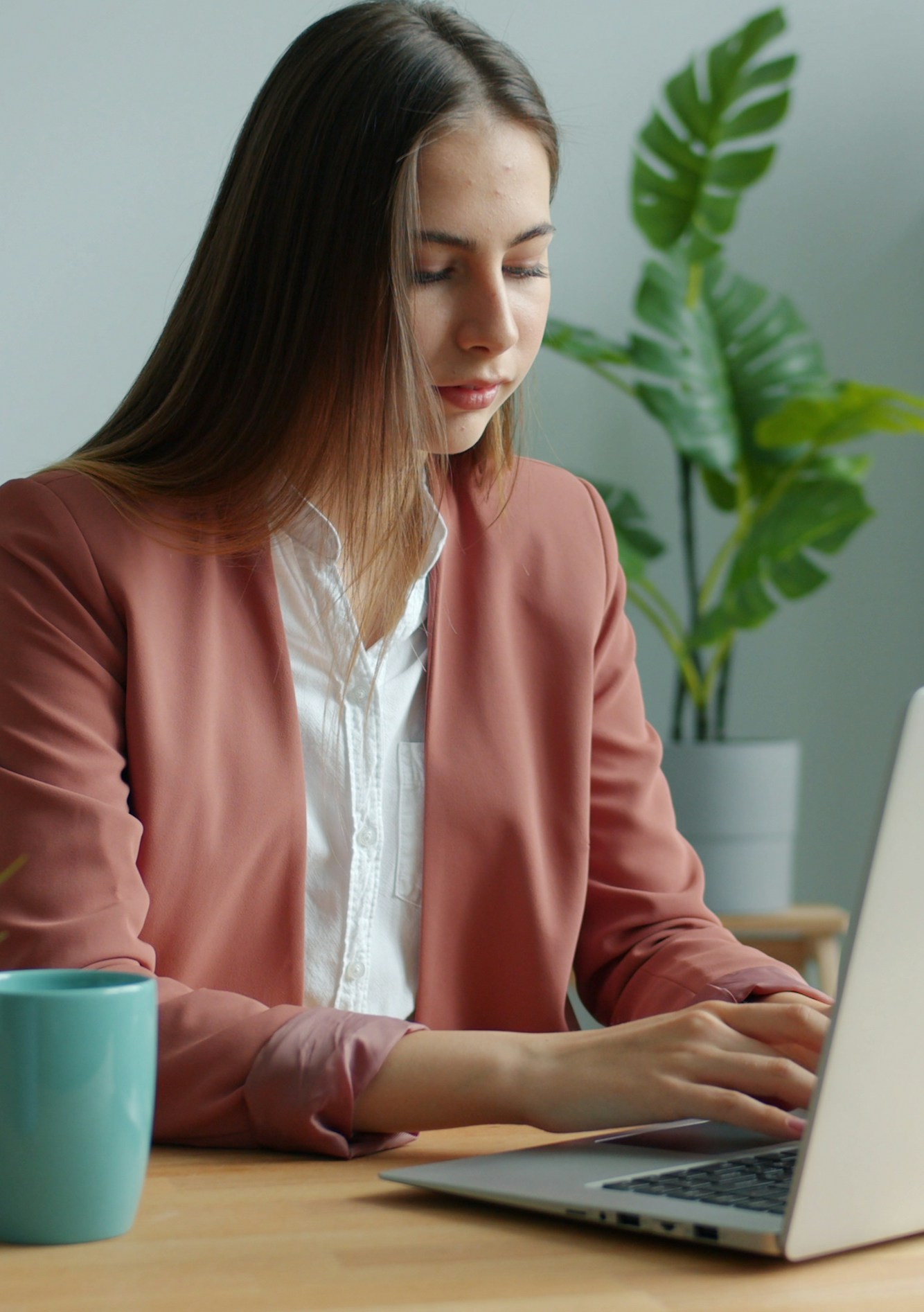 A professional working at a laptop in a bright office